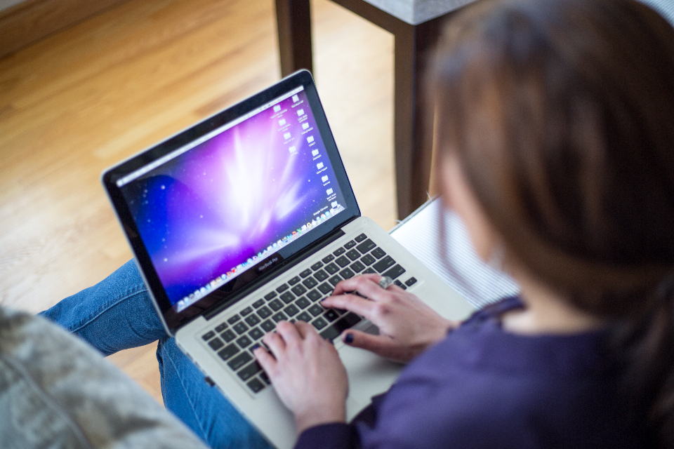A person using a computer in the dark, representing digital operations